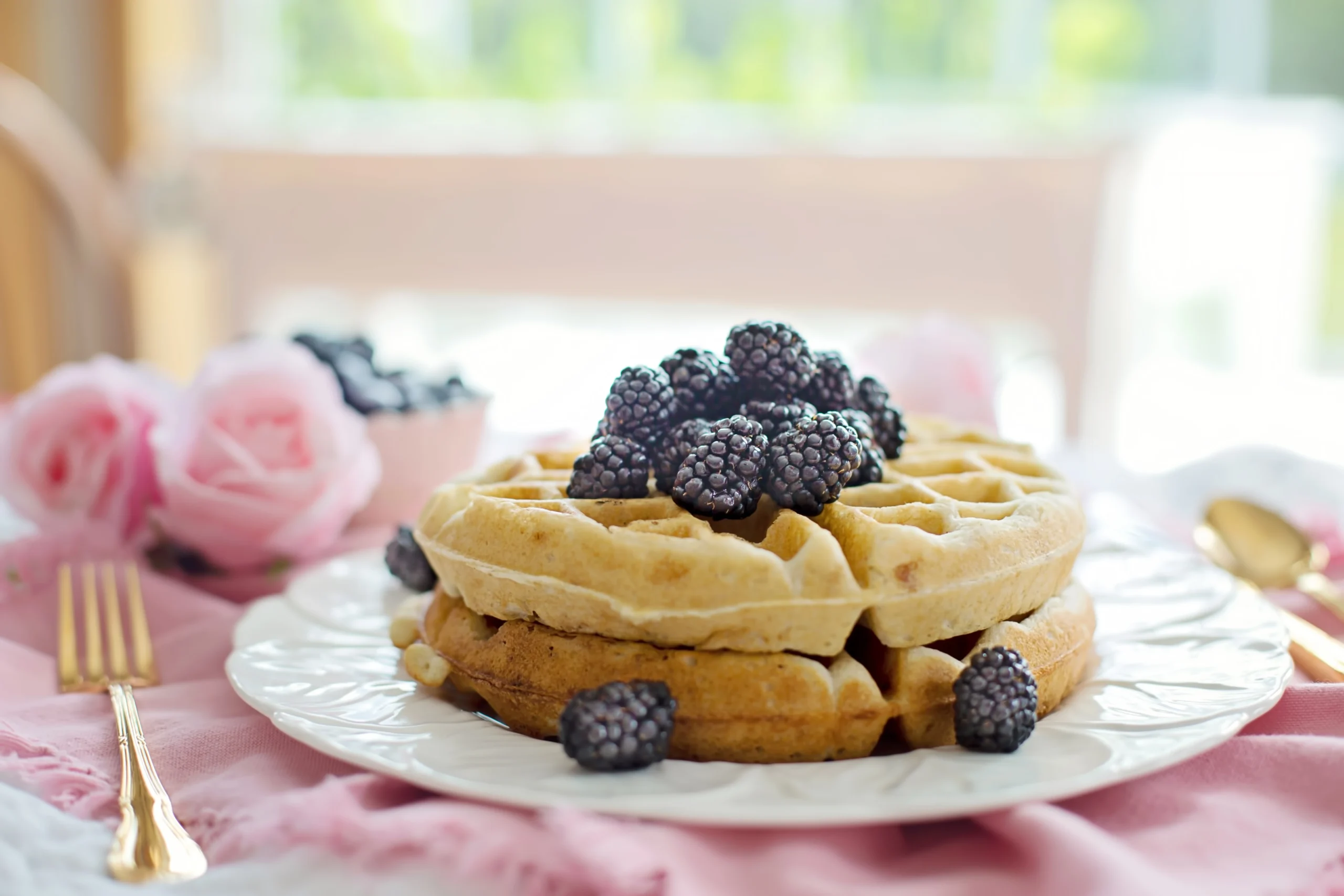 Waffles topped with blackberries and flowers.